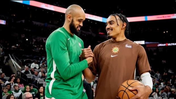 Dec 31, 2023; San Antonio, Texas, USA; San Antonio Spurs guard Tre Jones (right) speaks with former teammate Derrick White ahead of his team's matchup against the Boston Celtics.